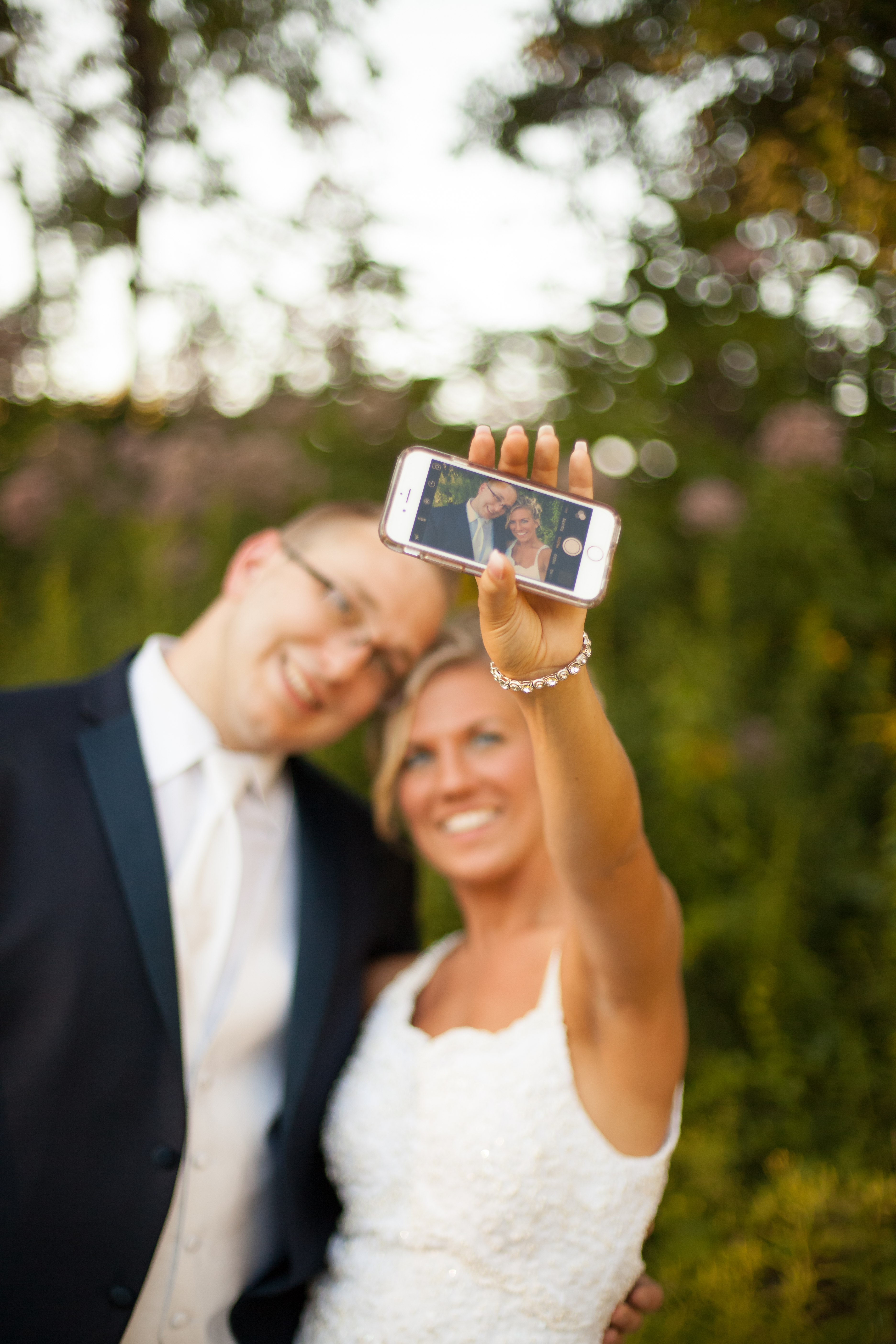 A bride and groom take a selfie during a first look